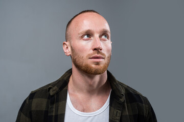 Obraz premium Studio shot of young man looking up. Handsome guy with confident face.
