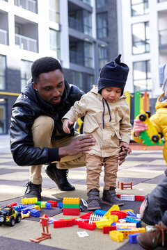 Father and son playing with toys together 