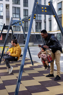 Dads having fun with kids on play area 