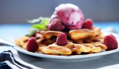 Belgian waffles with strawberry ice cream, fresh raspberries and mint