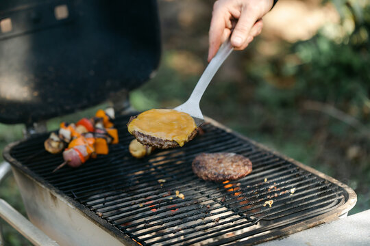Man Taking Cheeseburgers off Grill