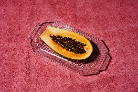 halved papaya fruit in a glass tray