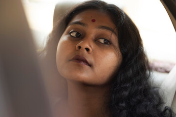 Young Indian woman inside car