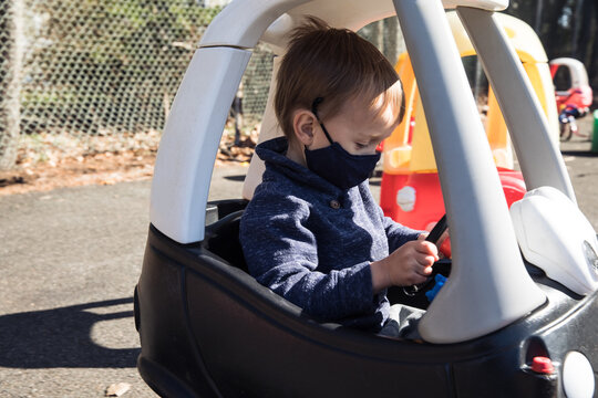 Little boy riding in black toy car