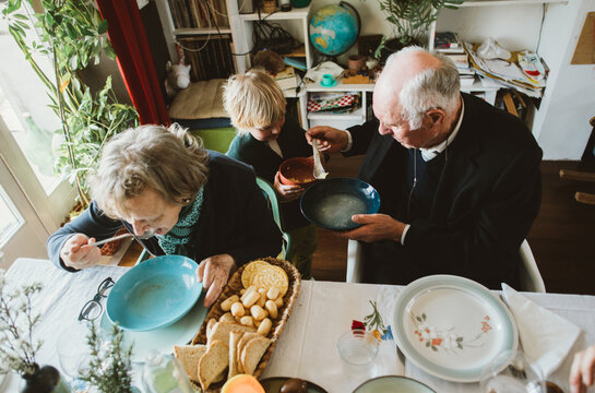 A senior man hand out tortellini  for a grandchild