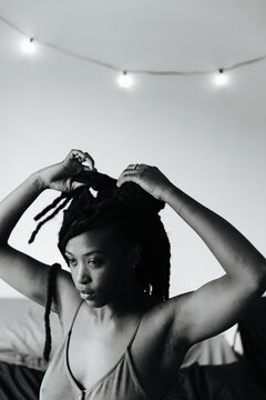 Young black woman adjusts her dreadlock hair