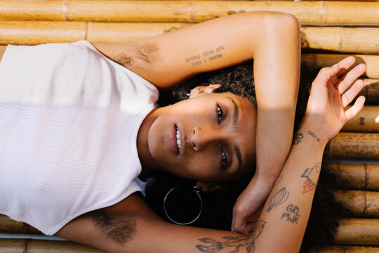 Happy Woman with afro and armpit hair with bamboo background