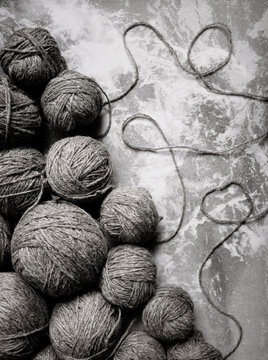 Balls of grey yarn on a dark marble backdrop