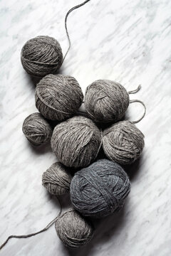 Balls of grey yarn on a simple marble backdrop