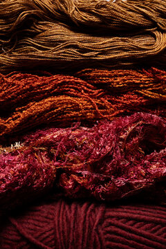 Closeup of yarn textures in red, orange and maroon shades