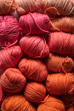 Balls of yarn in orange, coral and pink tones