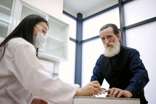 Old man having consultation in clinic with doctor 
