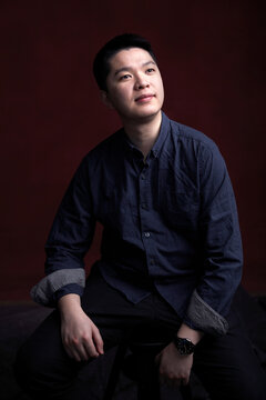 Portrait of young Asian man, indoors.