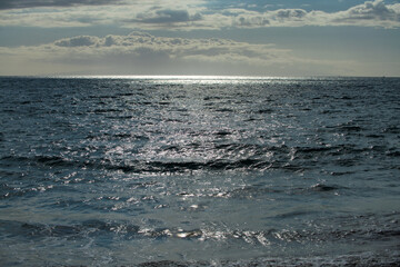 Sea abstract or rippled water texture background. Calm water surface texture with splashes and waves. Abstract nature background. Surface of blue ocean water.