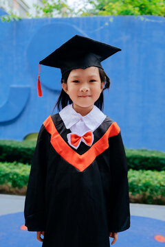 Asian little girl wearing kindergarten graduation costume