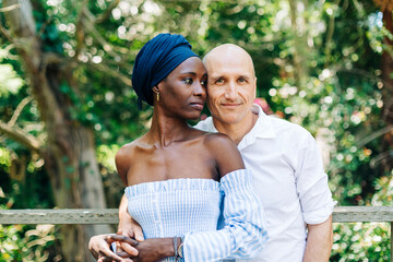 Diverse couple standing in embrace on nature