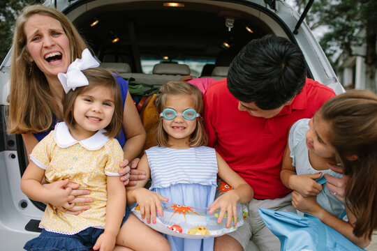 Family Of 6 Sitting In The Back Of Their Car Like They Are About To Go On A Trip