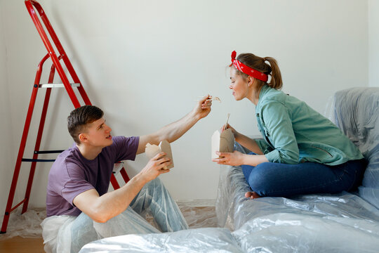 Couple sharing food during lunch in room under renovation