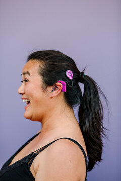 Happy woman with pink cochlear implant 