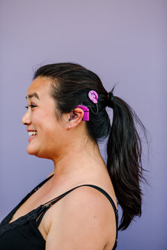 Woman with pink cochlear implant skins