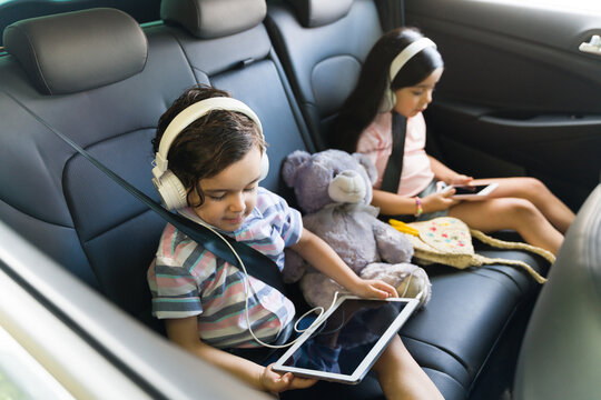 Adorable children playing video games in the car