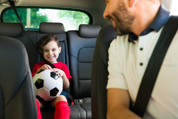 Hispanic man talking with his son in the car