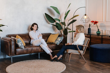 Young woman speaking with mature psychologist