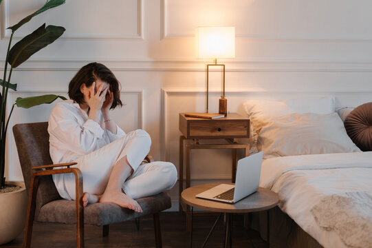 Anonymous woman crying near netbook