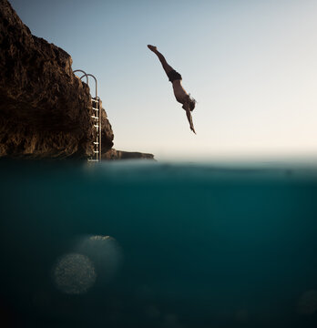 Male silhouette jumping into the sea