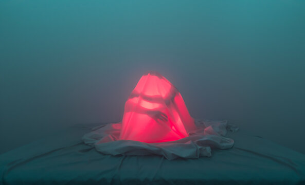 Human silhouette under bed sheets