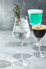 Cocktail with vodka and thyme. Summer day cocktail concept with sunlight and shadow. Cocktail in wine glass.