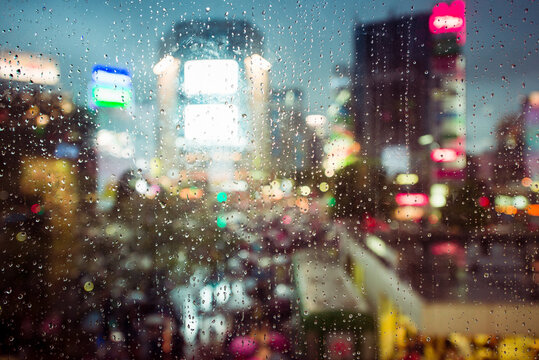 Rain on the glass and cityscape as a background