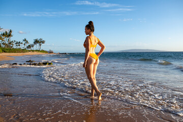 Beach vacation. Beautiful woman in bikini enjoying view of beach ocean on summer day, Hawaii.