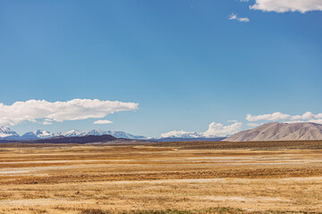 Arid plains against Sierra Nevada Mountains and clear blue sky 