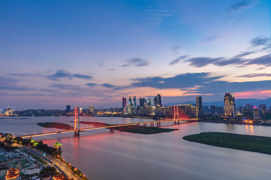 Stunning city skyline, full of sunset and rosy clouds, just like a dream. Above the Ganjiang River, the bridge passes through. Nanchang, China.