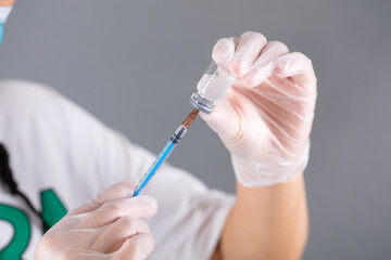The doctor sucks the vaccine medicine with a needle