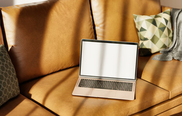 Open laptop on leather sofa