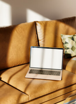 Open laptop on leather sofa