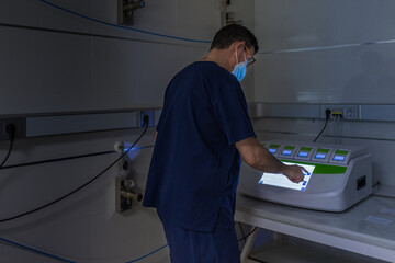 Medical specialist using a machine in IVF laboratory