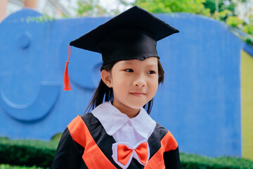 Asian little girl wearing kindergarten graduation costume