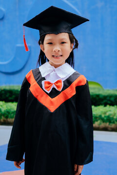 Asian little girl wearing kindergarten graduation costume