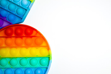 Trendy popular toy anti-stress POP it. Celicon rainbow toy for the development of children's motor skills on a pink background