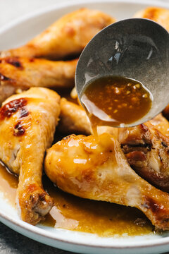 Pouring garlic soy over chicken