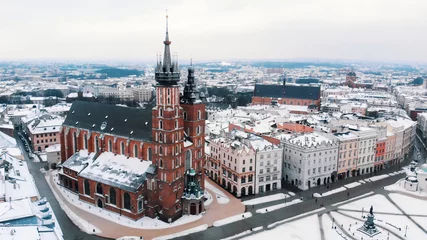 Fotobehang Aerial view of the Krakow’s Rynek Głowny (Central Square) surrounded by historic buildings. Twin towers of the Basilica of Saint Mary against clear white sky in the background. City Skyline. © CameraCraft
