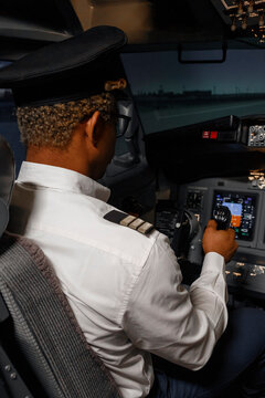 Black pilot steering plane on airfield