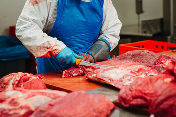 Butcher cutting meat in a factory