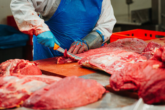 Butcher cutting meat in a factory