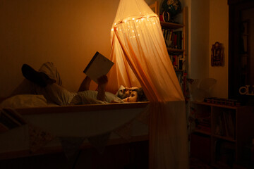Father and daughter reading a story in bed