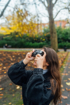 Woman taking Pictures of Autumn with an Old Camera