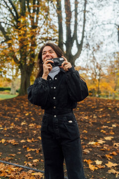 Woman taking Pictures of Autumn with an Old Camera